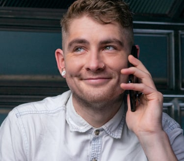 Dark haired man using his phone